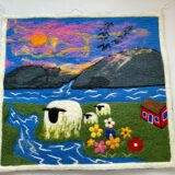 Needle felt painting of Sheep grazing in the ground