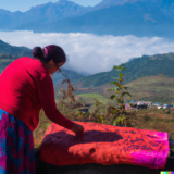 a women cleaning felt product with good landscape in background of Nepal